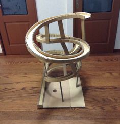 a metal object sitting on top of a wooden floor next to a door with two doors in the background