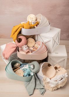 a pile of baby shoes and blankets sitting on top of each other in front of a box