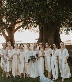 a group of women standing next to each other under a tree