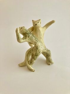 two ceramic figurines that look like they are dancing