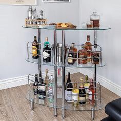 a glass shelf with liquor bottles on it in a living room next to a black leather chair