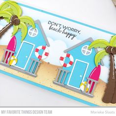 a handmade card with two beach huts and palm trees on the beach, says don't worry, beach happy