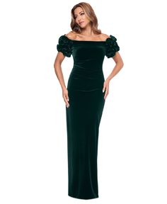 a woman wearing a green velvet gown with ruffled sleeves and an off the shoulder neckline