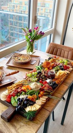 a wooden table topped with lots of different types of fruit and veggie platters