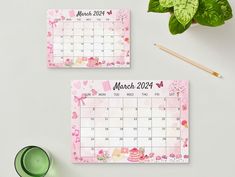 two calendars with pink flowers and hearts on them next to a cup of coffee