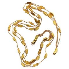 This 18k gold necklace consists of three strands of alternating gold bars and citrine briolette beads suspended between delicate gold chain. The shapes in this necklace are reminiscent of gold nuggets: the bars are moon-shaped wedges with a textured surface, while the citrine briollete beads are matched perfectly to the warm, buttery 18k gold, almost appearing to be made of gold as well. The two exterior strands contain both gold bars and citrine beads, while the center strand consists of only g Luxury Gold Briolette Necklaces, Luxury Gold Briolette Necklace, Luxury Gold Multi-strand Necklace, Luxury Multi-strand Gold Necklace, Elegant Yellow Chain Necklace With Delicate Chain, Elegant Gold Citrine Necklace, Luxury Gold Multi-strand Chain Necklace, Gold Multi-strand Chain Necklace In Luxury Style, Luxury Gold Double Strand Necklace