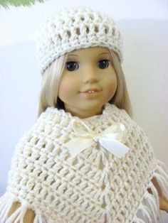 a doll is wearing a white crocheted ponchy