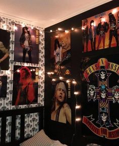 a bedroom decorated with pictures and lights on the wall, including an iron maiden cross