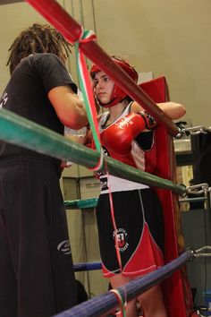 two women in red boxing gloves standing next to each other with their hands on the ropes