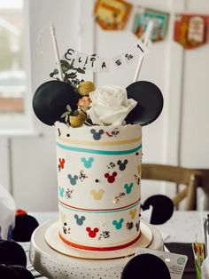 a mickey mouse cake is decorated with flowers