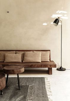 a wooden couch sitting next to a lamp on top of a table in a living room