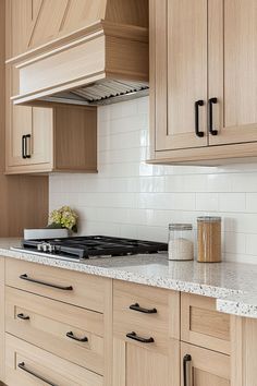 a kitchen with wooden cabinets and marble counter tops, along with white tile backsplash