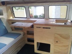 the interior of a small boat with wooden tables and benches on each side of it