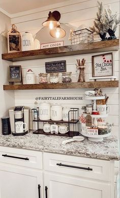 a kitchen with white cabinets and shelves filled with coffee cups, mugs and other items