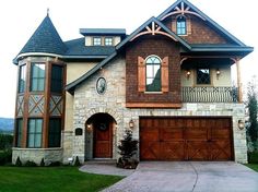 a large brick and stone house with two garages