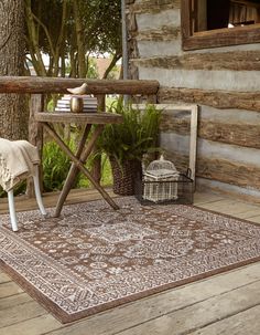 a wooden bench sitting on top of a wooden floor next to a rug and potted plant