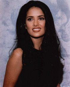 a woman with long black hair posing for a photo