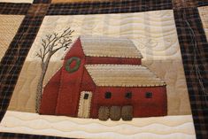 a quilted red barn with trees and snow on it