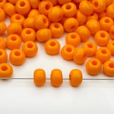 several orange beads sitting on top of a white surface