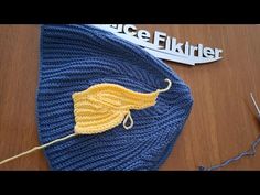 a crocheted hat is laying on a table next to a pair of scissors