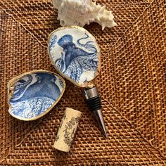 two small blue and white dishes sitting on top of a woven table cloth next to a cork bottle opener