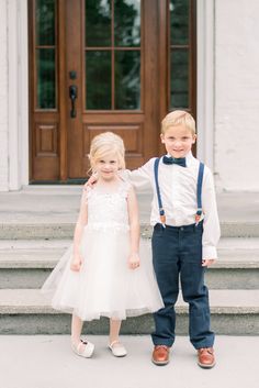 two young children in formal wear standing on steps