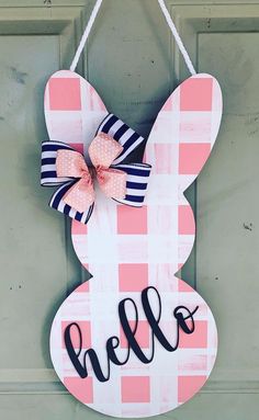 a door hanger with the word hello written on it and a pink checkered bunny ears