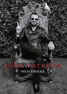 a black and white photo of a man sitting in a chair with two birds on his arm