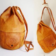 a brown leather purse sitting on top of a white table next to a wooden hanger