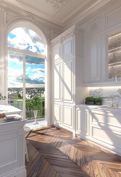 an empty kitchen with white cabinets and wood flooring, overlooking the city from its windows