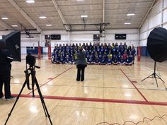 a group of people standing on top of a hard wood floor next to a camera