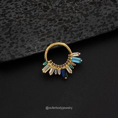 a gold ring with multicolored stones on it