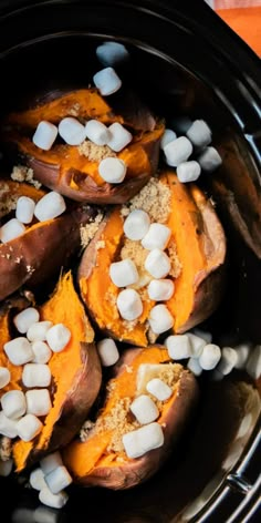 several sweet potatoes with marshmallows in a crock pot