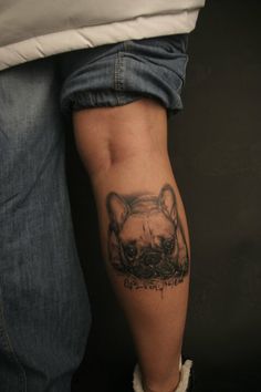 a person with a cat tattoo on their arm and leg, standing in front of a black background