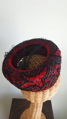 This stunning vintage hat features a striking red silk-velvet base that perches elegantly atop the head; dramatic, faceted black beading; a black net veil and center; and winding ribbon-like corde detailing. Era: 1940s Label: Macy's New York Rise: about 2.75 inches tall 7.5 inches long over top, front to back Vintage Cloche Headpieces For Evening, Elegant Bead Caps Headpieces For Evening, Elegant Evening Headpieces With Bead Caps, Red Evening Hat Headpiece, Net Veil, Large Brim Hat, Types Of Hats, Beaded Hat, Pillbox Hat