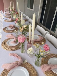 the table is set with white plates and pink napkins