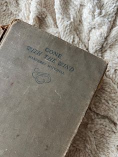 an old book sitting on top of a blanket