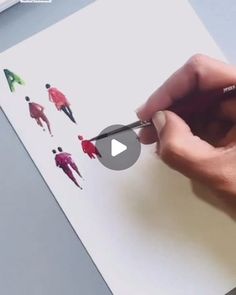 a person is drawing on paper with scissors