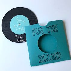 two records with the words for the record printed on them, one black and one teal