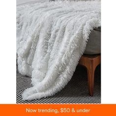 a fluffy white blanket on top of a bed