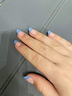 a woman's hand with blue nail polish on it