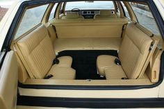 the interior of an old car with beige leather seats and black trims, parked in a parking lot