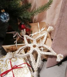 a star ornament sitting next to presents under a christmas tree