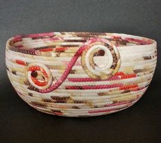 a close up of a woven basket on a black surface with red and white stripes