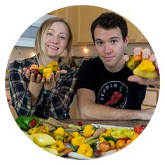 a man and woman sitting at a kitchen table with food in front of them on plates