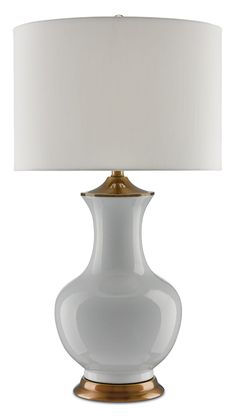 a white lamp with a gold base and a white shade on the top of it