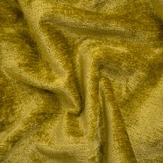 a close up view of a yellow fabric textured with metallic flecks and folds