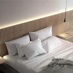 a bed with white pillows and blankets on it