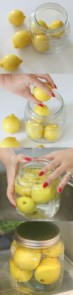 two hands reaching for yellow lemons in a glass jar on top of a counter