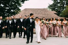 a bride and groom walking with their wedding party